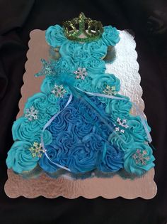 a cake with blue frosting and a tiara on top