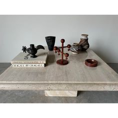 a wooden table topped with vases and books