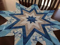 a blue and white quilted star sitting on top of a wooden table