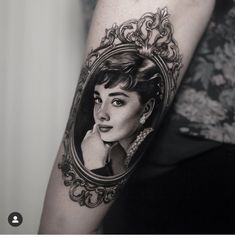 a woman's face in a mirror tattoo on the arm