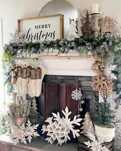 a fireplace decorated for christmas with stockings and snowflakes