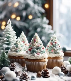 three cupcakes decorated with white frosting and christmas trees on top of snow