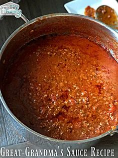 a pot filled with sauce sitting on top of a wooden table