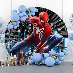 a spiderman birthday party with balloons, streamers and confetti on the table