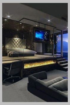 a bedroom with a large bed, couches and a flat screen tv on the wall