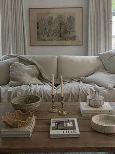 a living room with a couch, coffee table and pictures on the wall above it