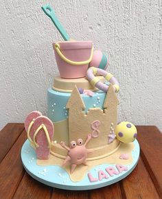 there is a cake that looks like it has a sandcastle on top and beach toys in the bottom