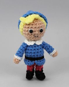 a small crocheted doll wearing blue and red pants