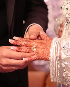 the bride and groom are holding their hands together