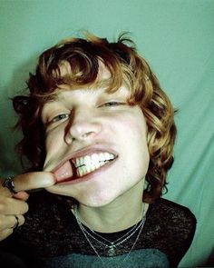 a young man making a silly face while brushing his teeth