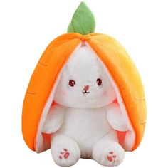 a white stuffed rabbit with an orange carrot on its head and ears, sitting in front of a white background