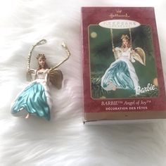 a christmas ornament next to a boxed package for barbie's dollhouse