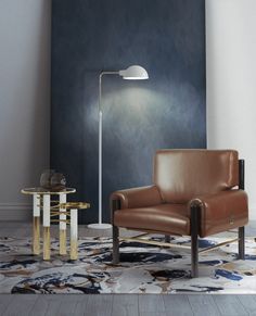 a living room with a chair, table and lamp on the floor in front of a blue wall