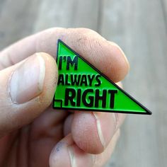 a person holding a green triangle pin with the words i'm always right on it