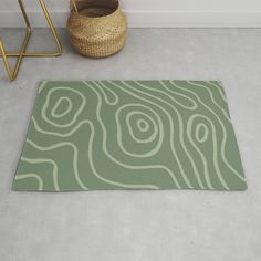 a green rug on the floor next to a basket