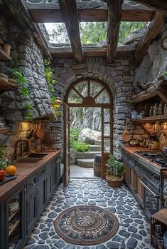 a kitchen with stone walls and an arched doorway leading to the outside area is shown