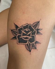 a black and white rose tattoo on the thigh