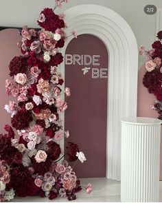 the entrance to a bridal be store with flowers on it's wall and door