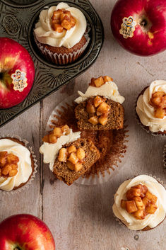 apples and cupcakes with white frosting on a table