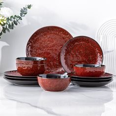 a red dinnerware set on a white table