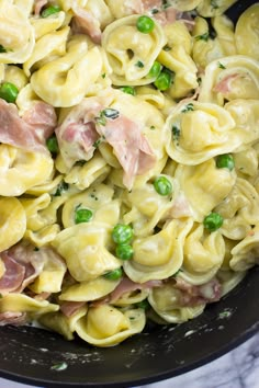 pasta with peas and ham in a black skillet