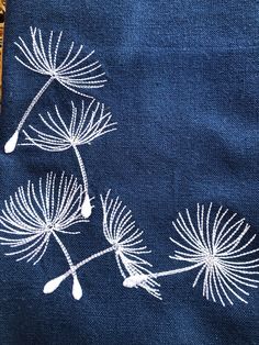 an embroidered piece of cloth with white flowers on it