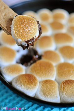 a spoonful of marshmallows being lifted from a skillet