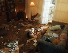 a person laying on the floor in a messy living room