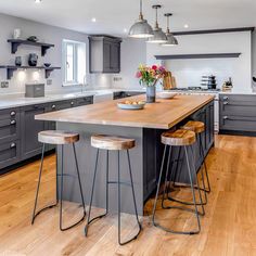 a kitchen with gray cabinets and wooden floors