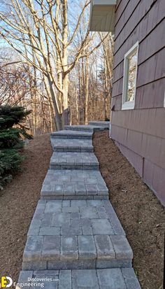 some steps leading up to a house with trees in the back ground and bushes on either side