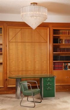 a room with a desk, bookshelf and chair in it's center