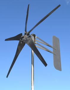 a metal wind turbine with four blades attached to it's side against a blue sky