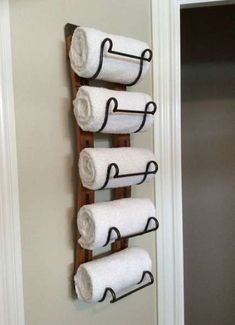 three towels are hanging on a towel rack in the bathroom, and one is made from an old ladder