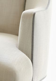 the back end of a white chair with black stitching on it's arm