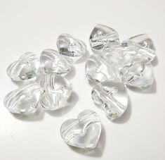 several clear glass hearts on a white surface