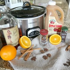 ingredients for an apple cider recipe sitting on a kitchen towel next to the crock pot