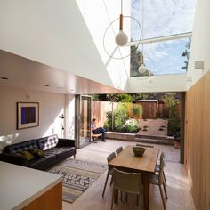 an open living room and dining area with skylights above the kitchen table in this modern home