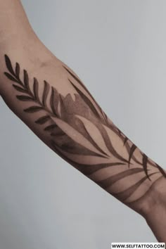 a person's arm with an artistic tattoo design on the left side of their arm