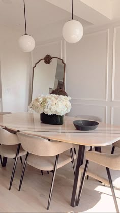 a dining room table with chairs and a mirror