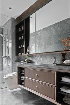 a modern bathroom with marble counter tops and gray walls, along with an open shower