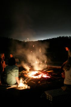 people sitting around a campfire at night