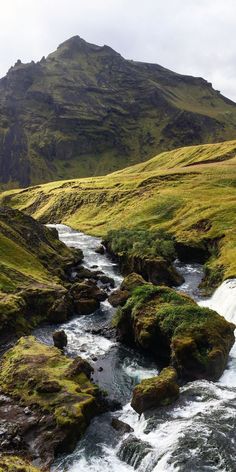 a stream running through a lush green valley