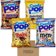 four bags of candy pop sitting on top of a cardboard box