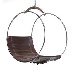 a brown leather swing chair hanging from a metal frame with two circular rings around it