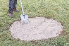 a man is shoveling sand in the middle of a hole with a shovel on it