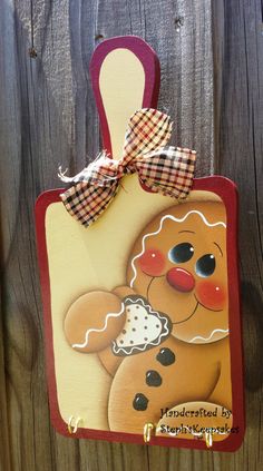 a wooden plaque with a gingerbread dog on it's side hanging from a fence