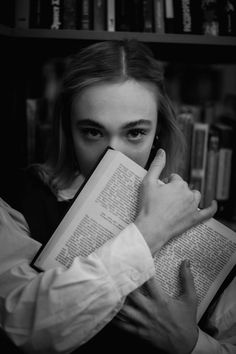 a woman holding an open book in front of her face