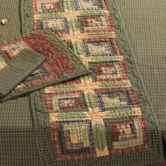 a quilted table runner and matching placemats on a green plaid bed spread