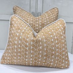 two pillows sitting on top of a bed