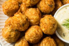 some fried food on a plate with a small bowl of ranch dressing next to it